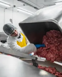 Staff inspecting sausage links in USDA-inspected facility